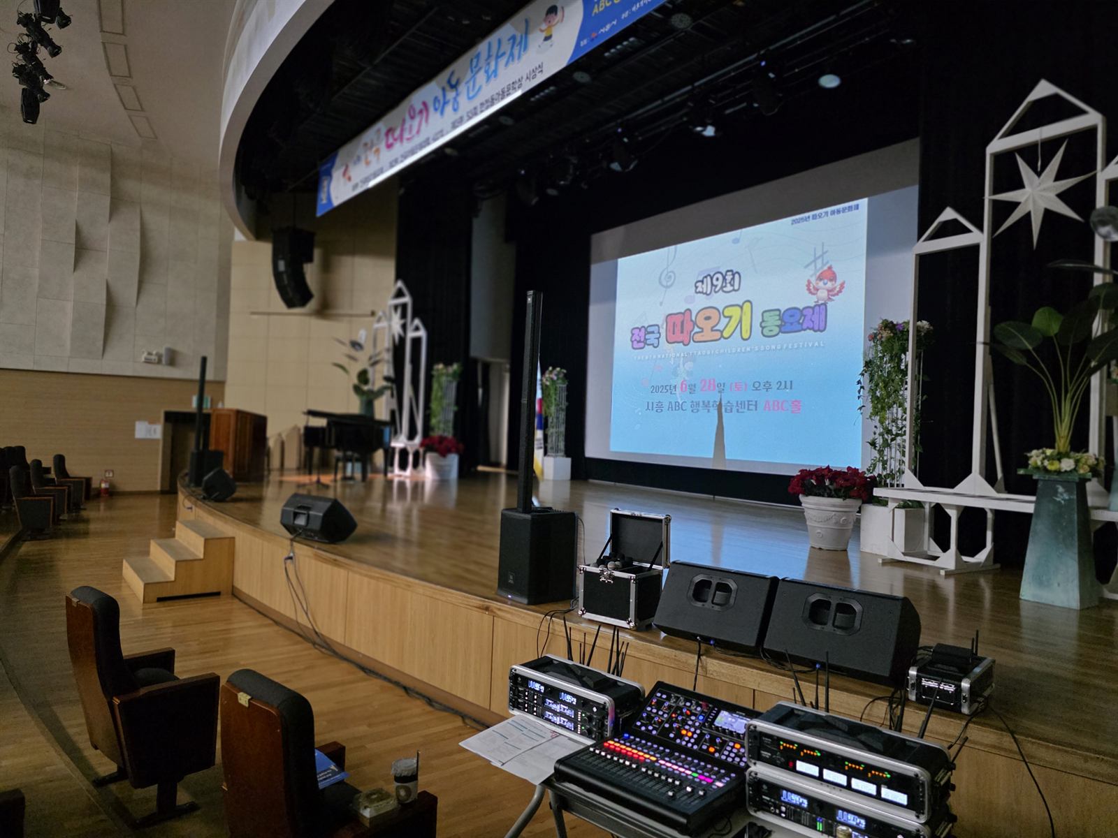 공연장 무대 앞에 설치한 공연용 음향장비와 디지털 믹서