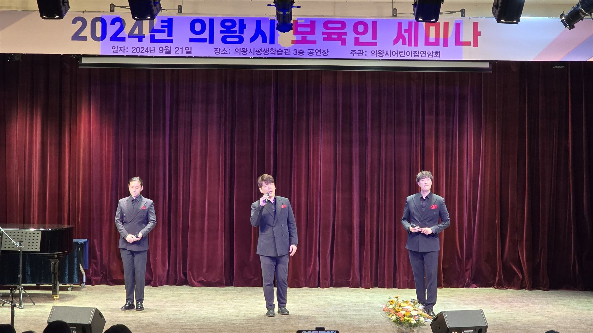 붉은 막 앞 무대에서 노래하는 팝페라 제이보이스 3인